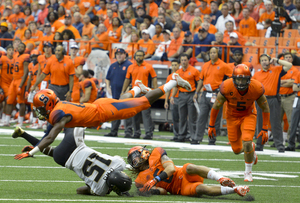 A Syracuse defender flies over Demon Deacons receiver Cortez Lewis trying to make a tackle.